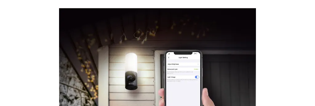 Escena oficial de iluminación nocturna con EZVIZ LC3 y control mediante aplicación; teléfono no incluido.